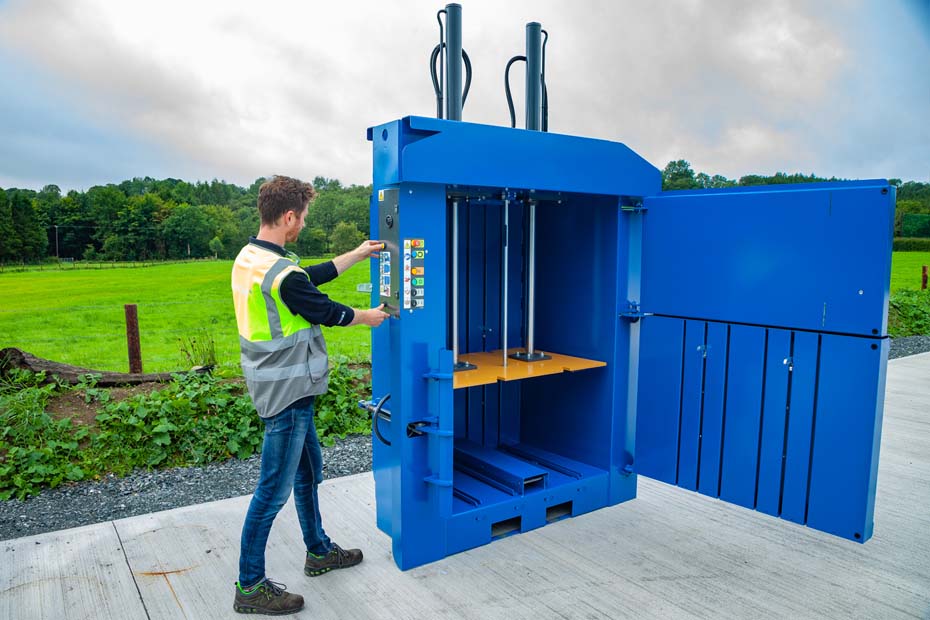 operator using eject buttons on a cardboard baler.