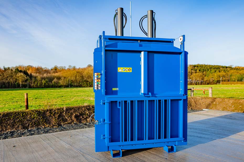 A large vertical baler with top sliding door.